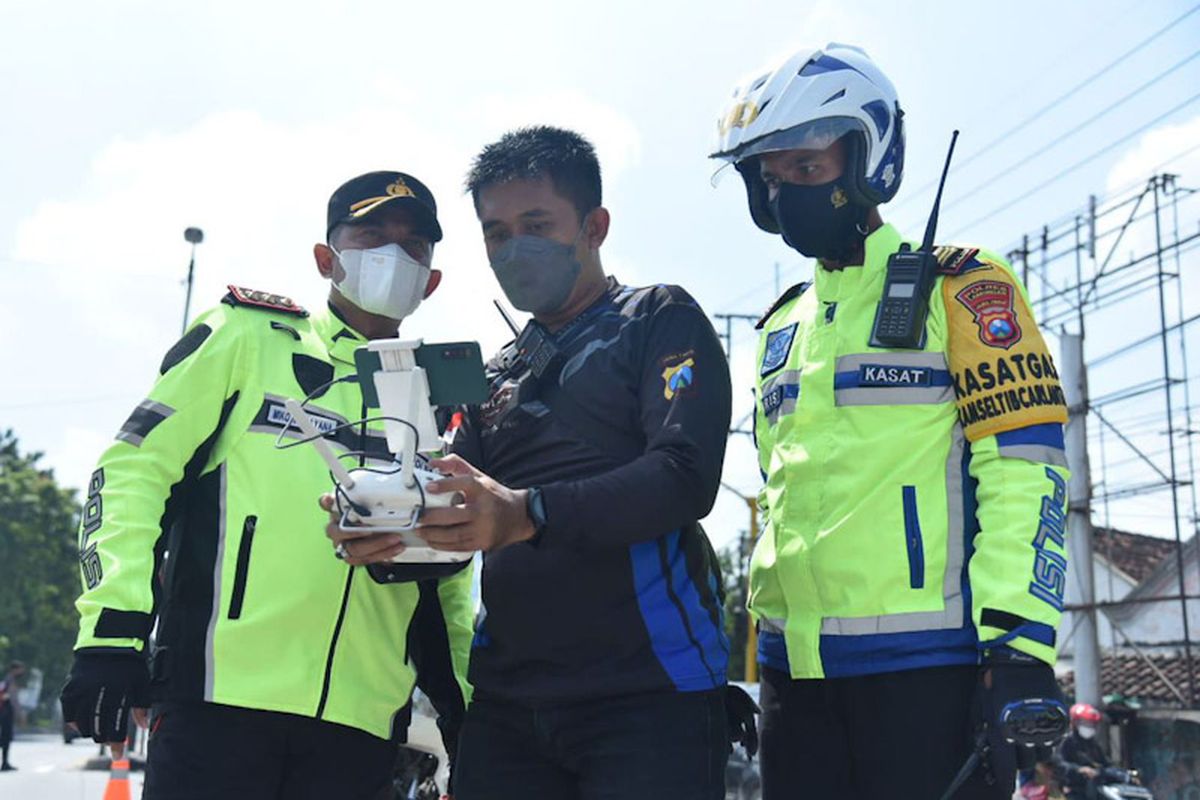 Kapolres Lamongan AKBP Miko Indrayana (kiri) bersama Kasatlantas Polres Lamongan AKP Aristianto Budi Sutrisno (kanan), melihat drone yang digunakan memantau arus lalu lintas.