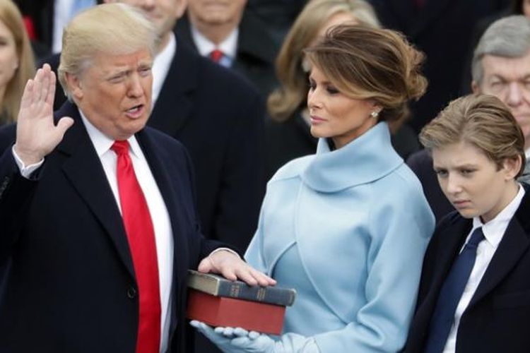 Donald Trump, didampingi istrinya, Melania, membacakan sumpah saat dilantik menjadi presiden ke-45 Amerika Serikat, Jumat (21/1/2017).