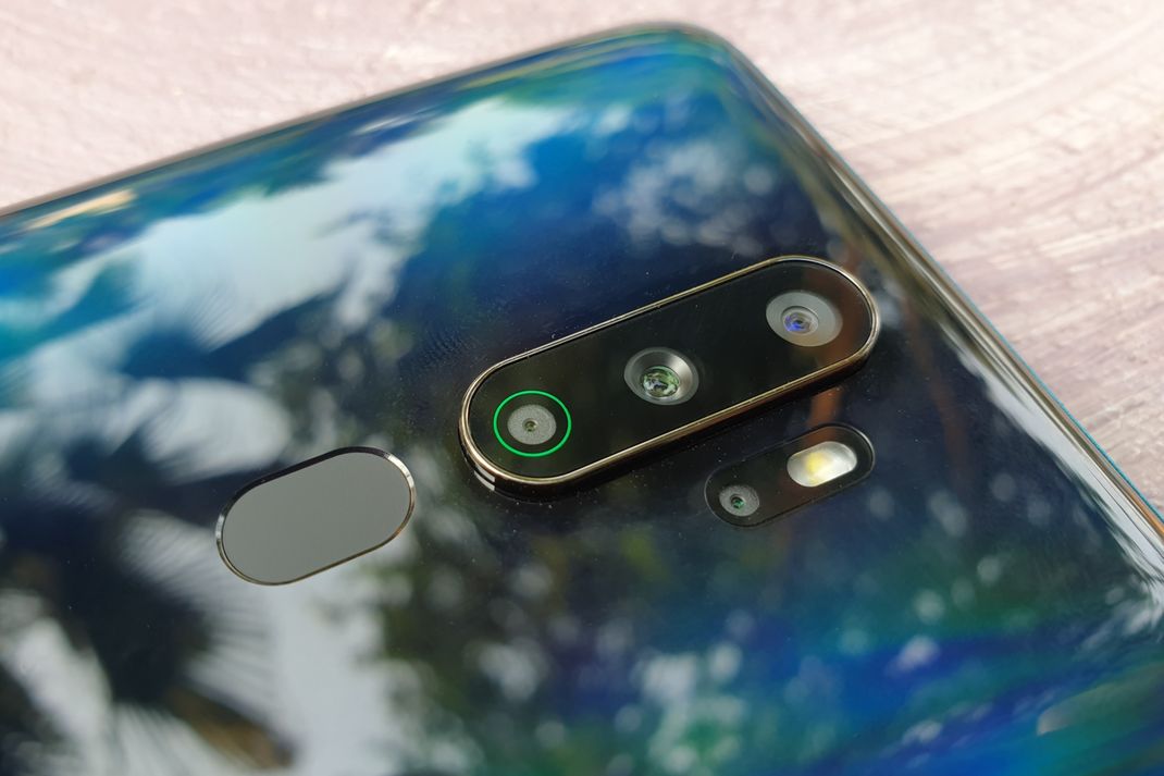 Susunan kamera Oppo A9 2020. Secara berurutan, susunan kamera yang paling atas adalah kamera ultrawide dengan resolusi 8 megapiksel. Di bawahnya ada kamera utama yang beresolusi 48 megapiksel. Kemudian susunan kamera terakhir adalah kamera monokrom yang beresolusi 2 megapiksel. Lantas, di mana kamera keempatnya? Kamera portrait lens dengan resolusi 2 megapiksel tersebut terletak di samping susunan ketiga kamera tadi, membawahi modul LED flash. Di bawah susunan kamera vertikal tadi ada pula fitur biometrik fingeprint sensor yang berbentuk elips. (KOMPAS.com/Bill Clinten)
