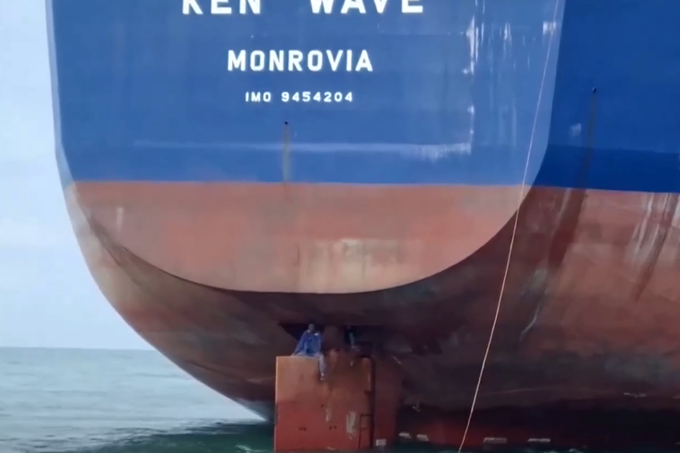 Tangkapan layar dari video yang memperlihatkan migran Nigeria hendak diselamatkan oleh polisi Brasil saat mereka duduk di daun kemudi kapal setelah melintasi Atlantik.