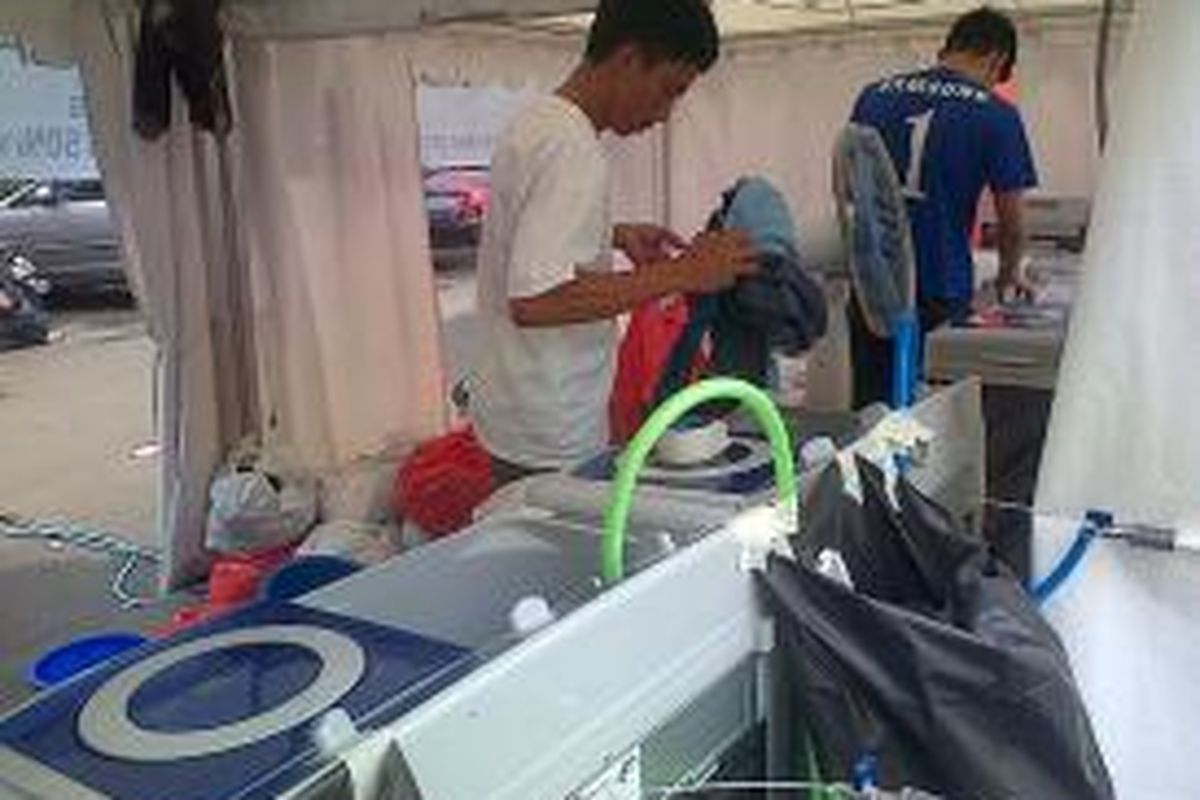 Stan pencucian baju gratis bagi korban banjir di Gelanggang Olahraga Remaja (GOR) Otista, Bidara Cina, Jakarta Timur, Selasa (28/1/2014).