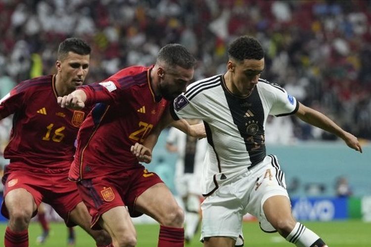 Hasil Spanyol vs Jerman: Jamal Musiala (kanan) berduel dengan Dani Carvajal (kiri) pada laga Grup E Piala Dunia 2022 Qatar yang mempertemukan Spanyol vs Jeman di Al Bayt Stadium, Senin (28/11/2022) dini hari WIB. Hasil Piala Dunia 2022 Spanyol vs Jerman imbang 1-1.