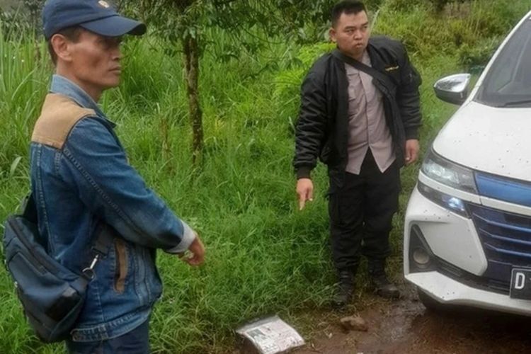Petugas kepolisian dari Polsek Pangalengan saat menunjukan titik lokasi aksi perampokan yang dialami oleh seorang pengemudi taksi online di Desa Wanasuka, Kecamatan Pangalengan, Kabupaten Bandung, Jawa Barat pada Minggu (14/4/2024).