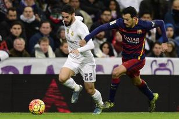 Isco (kiri) dan Sergio Busquets berduel saat Real Madrid bertemu Barcelona pada lanjutan La Liga di Stadion Santiago Bernabeu, Sabtu (21/11/2015).