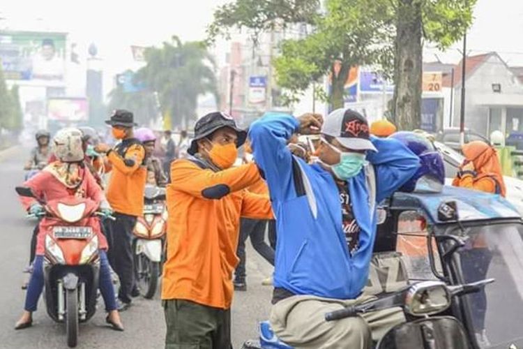 Petugas BPBD membagikan masker kepada masyarakat dan pengguna jalan di Kota Padang Sidempuan. Dampak kabut asap, sebanyak 50.000 pelajar di Kota Padang Sidempuan diliburkan, Rabu (25/9/2019)