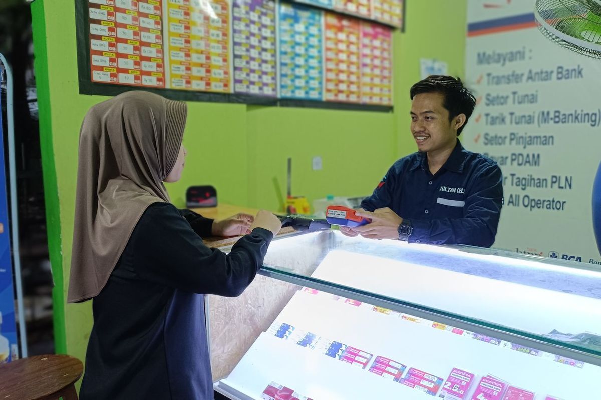 Agen BRILink bernama Hadriansah di counter pulsa miliknya di Pasar Induk Kramat Jati, Jakarta Timur