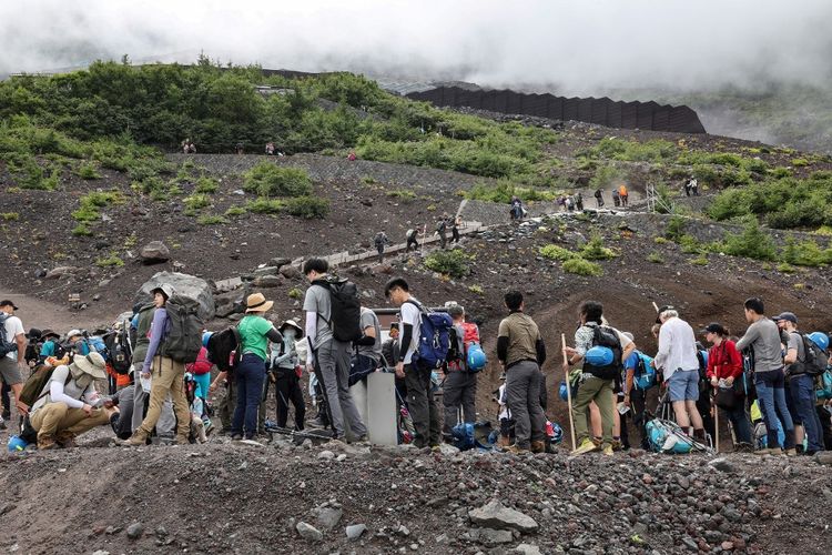 Foto yang diambil pada Kamis (31/8/2023) ini menunjukkan pendaki di lereng Gunung Fuji, puncak tertinggi di Jepang dengan ketinggian 3.776 meter. Gunung Fuji kini tidak lagi tenang, seperti yang telah dikenal sejak dulu, lantaran dipadati oleh jutaan pengunjung setiap tahun ditambah dengan banyak bus, truk penyuplai, toko mie, dan toko suvenir.