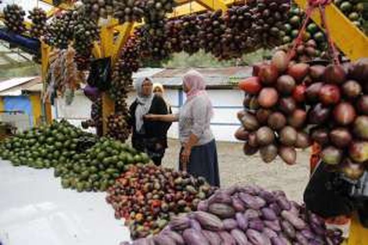 Penjual menjelaskan buah-buahan serta terong pepino (Solanum muricatum Aiton) yang dijual di warung miliknya dekat pintu masuk obyek wisata Situ Patenggan yang terletak di Desa Patengan, Kecamatan Rancabali, Kabupaten Bandung, Jawa Barat, Rabu (28/9/2016). Obyek wisata Situ Patenggan termasuk ke dalam kawasan Taman Wisata Alam (TWA) Telaga Patengan.