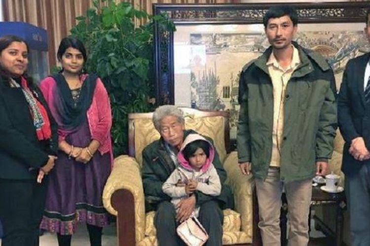 Wang Qi (77) tiba kembali di China setelah 45 tahun terjebak di India.  Wang duduk dikelilingi keluarganya.