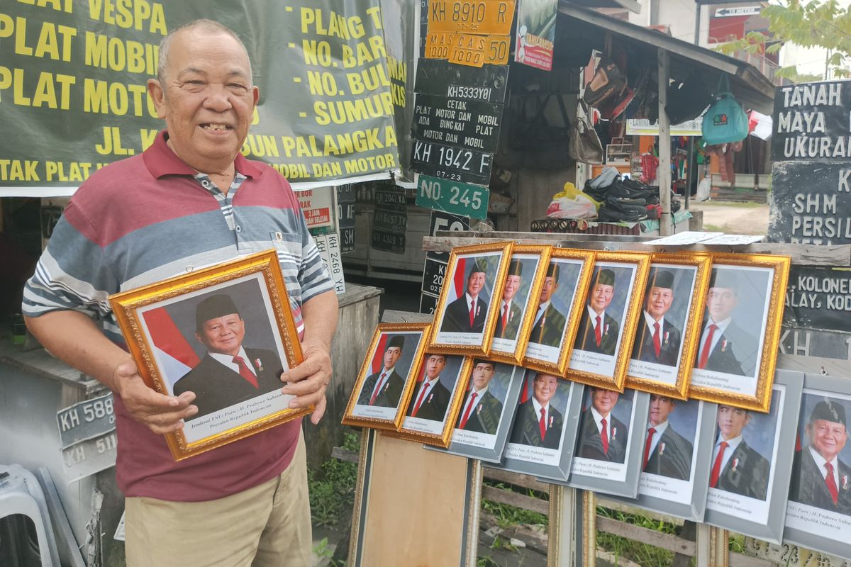 Pedagang foto dan figura di Jalan KS Tubun, Kota Palangka Raya, Provinsi Kalimantan Tengah, Muhammad Aini (65), saat menunjukkan dagangannya, Jumat (25/10/2024) pagi.