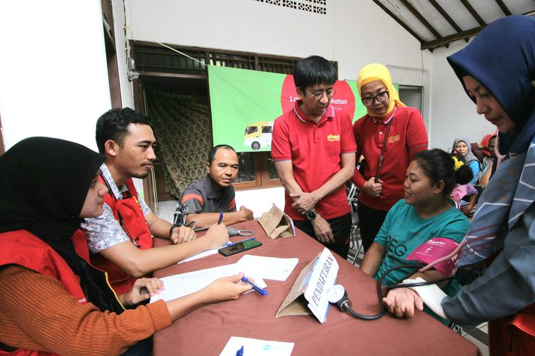 Hendri Mulya Syam, Chief Sales & Distribution Officer Indosat Ooredoo (berdiri kiri) dan Turina Farouk, SVP-Head Corporate Communications Indosat Ooredoo (berdiri kanan) saat turun ke posko pengungsian menyaksikan layanan pengobatan gratis di posko banjir Pangadegan, Jakarta Selatan.