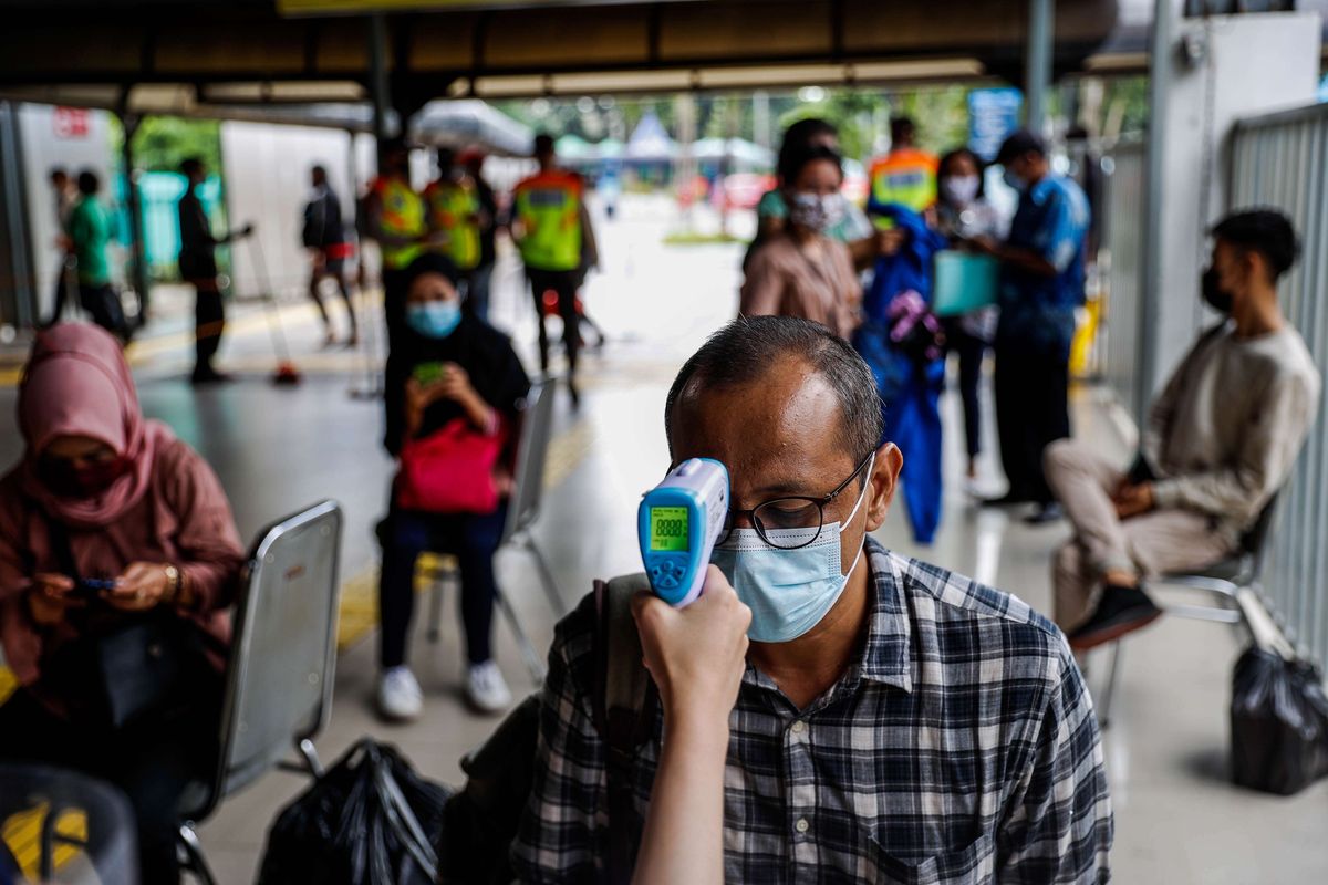 Petugas mengukur suhu tubuh calon penumpang KRL (Kereta Rel Listrik) yang akan melakukan tes usap antigen di Stasiun Tanah Abang, Jakarta Pusat, Senin (21/6/2021). PT KAI Commuter melakukan tes acak kepada penumpang KRL dari tanggal 21-27 Juni 2021 guna mencegah penyebaran wabah Covid-19.