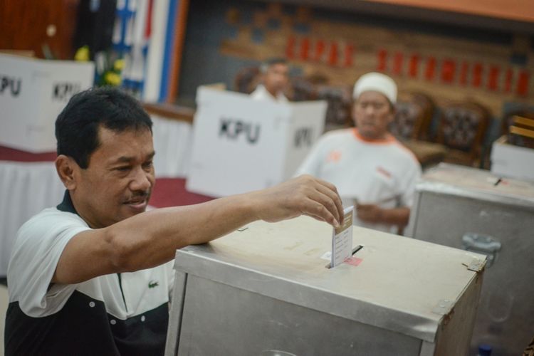 Warga binaan Lapas Sukamiskin yang juga mantan Bupati Bogor Rahmat Yasin memasukkan surat suara ke dalam kotak suara saat memberikan hak suaranya di TPS 51 Lapas Sukamiskin, Bandung, Jawa Barat, Rabu (27/6/2018).  Lapas Klas I Sukamiskin menggelar pemilihan calon Gubernur dan Wakil Gubernur Provinsi Jawa Barat serta Calon Walikota dan Wakil Walikota untuk 201 warga binaan yang berada di Lapas tersebut. 