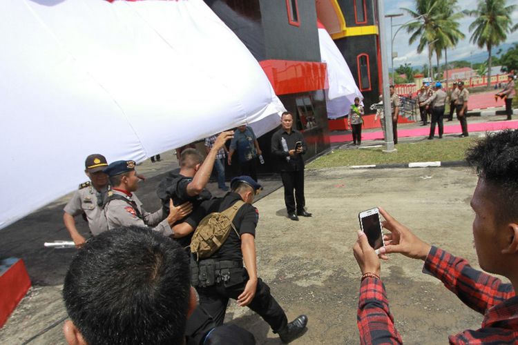 Dua orang angota Brimod Polda Gorontalo dievakuasi sejumlah rekannya setelah terkena ledakan balon gas menjelang peresmian Sekolah Polisi Negara (SPN) Batudaa.