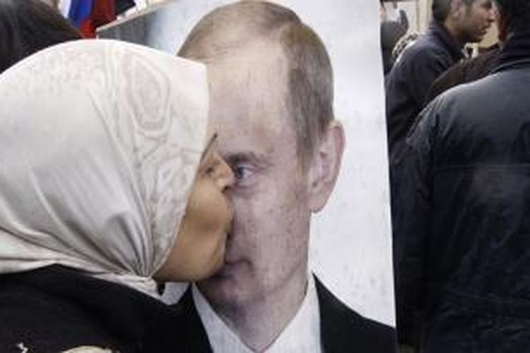 Seorang warga Suriah mencium gambar Presiden Rusia, Vladimir Putin.