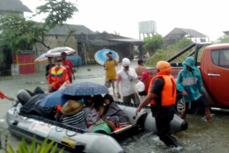 Petugas dan relawan BPBD Kabupaten Blitar melakukan evakuasi terhadap warga yang terjebak di rumahnya akibat banjir, Senin (17/10/2022)