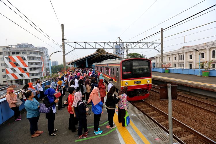 Sejumlah penumpang kereta listrik (KRL) Jabodetabek menunggu di garis batas antrean berwarna hijau di Stasiun Juanda, Jakarta Pusat, Rabu (9/8/2017). Garis batas antrean ini dibuat agar arus keluar masuk penumpang lebih teratur dan diharapkan dapat menghindari aksi saling mendorong sesama penumpang KRL.