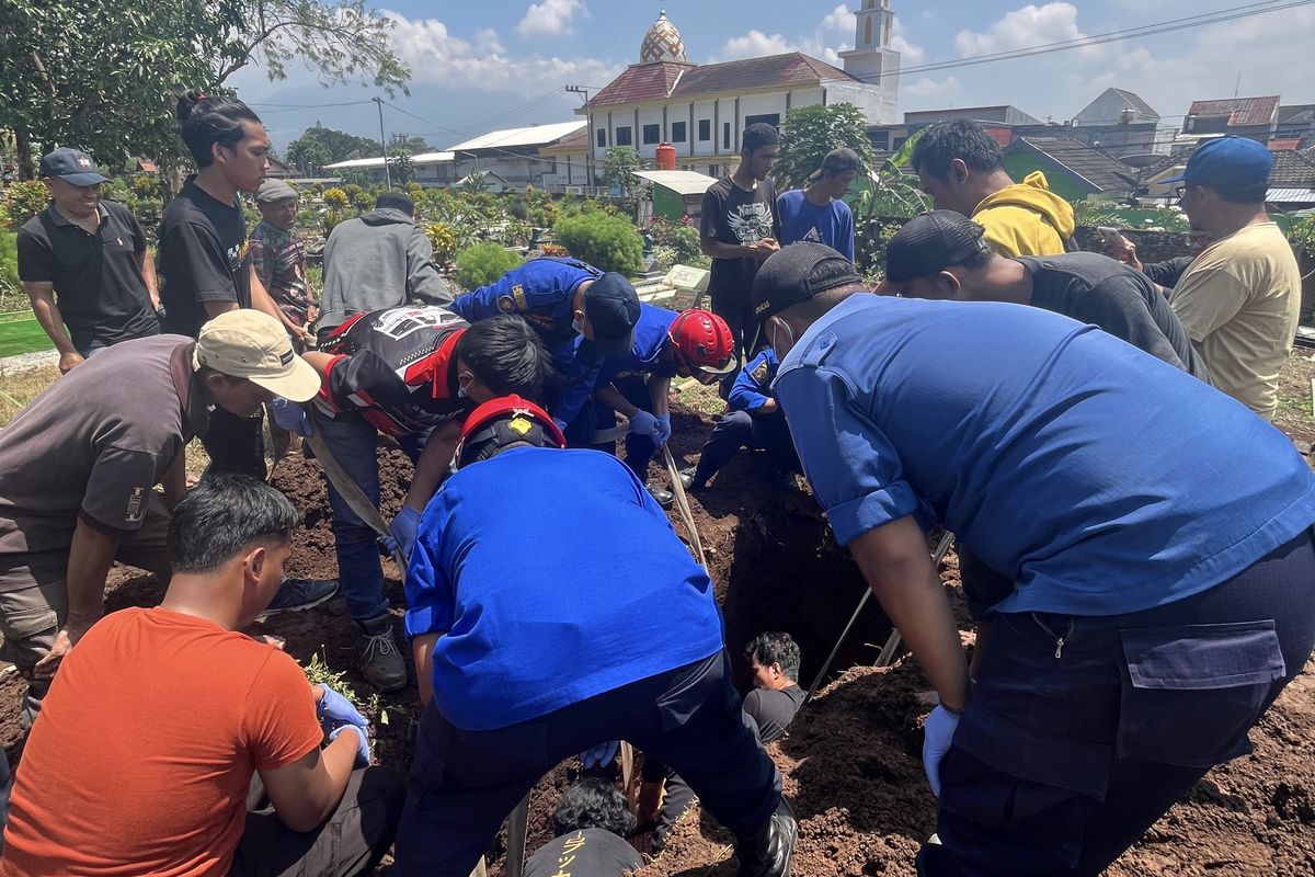 Personel Pemadam Kebakaran (Damkar) Kabupaten Malang saat memakamkan jenazah obesitas di Desa Mondoroko, Kecamatan Singosari, Kabupaten Malang, Sabtu (20/9/2025).
