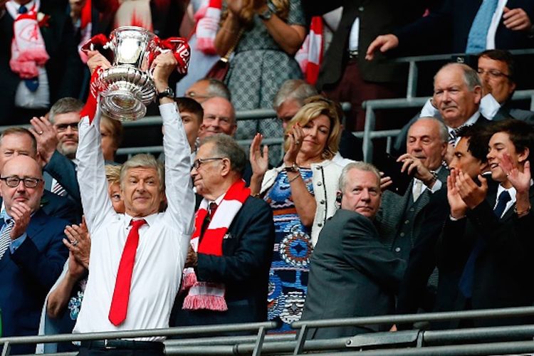 Arsene Wenger mengangkat trofi Piala FA seusai mengantarkan Arsenal menjadi juara dengan mengalahkan Chelsea pada laga final di Stadion Wembley, Sabtu (27/5/2017). 