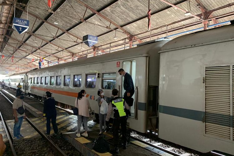 TURUN—Penumpang turun dari kereta api jarak jauh di Stasiun Madiun, Selasa (21/12/2021).
