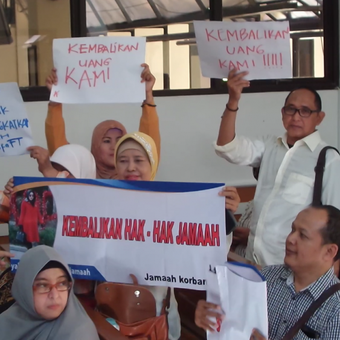 Sejumlah korban agen travel umrah PT First Travel mengacungkan spanduk saat menghadiri sidang perdana kasus dugaan penipuan dan penggelapan uang calon jamaah di Pengadilan Negeri Depok, Senin (19/2/2018).