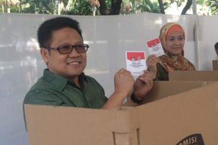 Ketua Umum Partai Kebangkitan Bangsa Muhaimin Iskandar, beserta istri menunjukkan surat suara usai mencoblos di TPS 01 Kelurahan Senayan, Kompleks Widya Chandra, Jakarta, Rabu (9/7/2014).