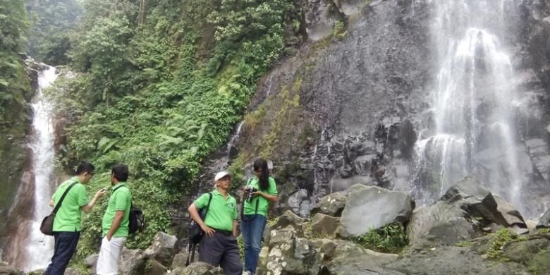 Pengunjung di antara dua air terjun, Curug Cigamea (kiri) dan Curug Cimudal (kanan) di Kawasan Taman Nasional Gunung Halimun Salak (KTNGHS), Kabupaten Bogor, Jawa Barat.