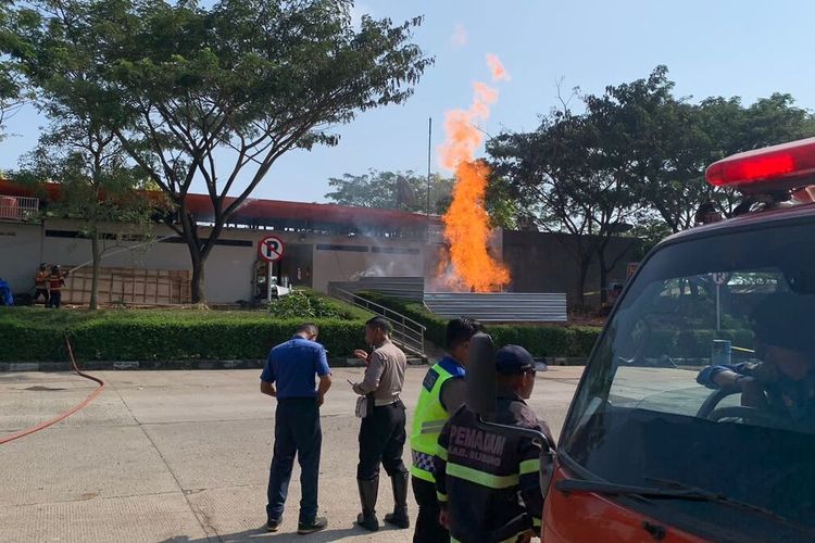 Polisi dan petugas pemadam Kebakaran baran tengah membantu melakukan penanganan semburan api yang menyembur dari sumur yang berada di lokasi parkir di rest area 86 Tol Cipali, Subang.