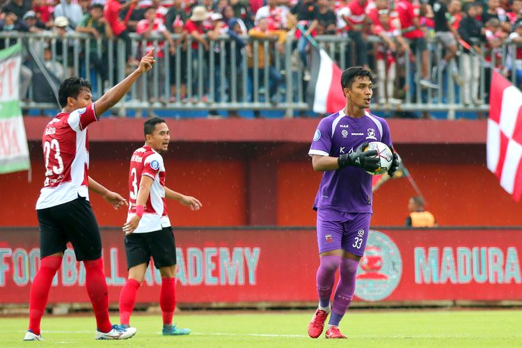 Penjaga gawang Madura United Miswar Saputra seusai menangkap tendangan pemain Persebaya Surabaya Alei Slamat saat pertandingan pekan ke-21 Liga 1 2022-2023 yang berakhir dengan skor 0-2 di Stadion Gelora Ratu Pamelingan Pamekasan, Minggu (29/1/2023) sore.