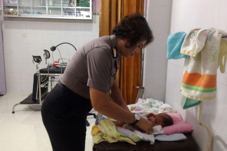 Kapolsek Jebres AKP Juliana Bangun menengok kondisi bayi berjenis kelamin laki-laki yang dibuang dan ditemukan di depan kios tambal Jalan Ir Juanda, Kampung Sewu, Kecamatan Jebres, Kota Solo, Selasa (27/2/2018).