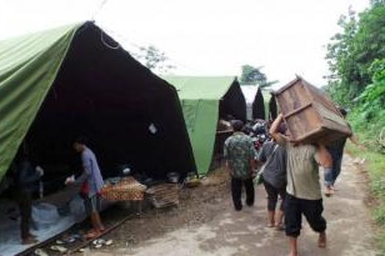 Warga RT 06/10, Trangkil Baru, Sukorejo, Gunungpati, memindahkan perabot rumah mereka, Jumat (24/1/2014). Pascalongsor mereka tinggal di tenda pengungsian. 