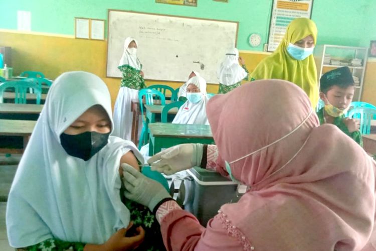 Murid-murid MI As-Syafi'iyah, Desa Tejo, Kecamatan Mojoagung, Kabupaten Jombang, Jawa Timur, menjalani vaksinasi Covid-19 di sekolahnya, Kamis (16/12/2021).