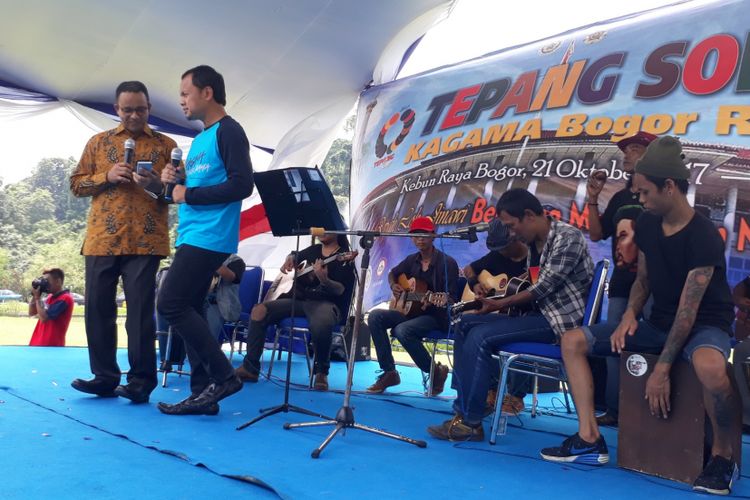 Gubernur DKI Jakarta Anies Baswedan bersama Wali Kota Bogor Bima Arya Sugiarto bernyanyi dan berjoged bersama lagu dangdut dalam acara pengukuhan pelantikan Keluarga Alumni Gadjah Mada (KAGAMA) di Kebun Raya Bogor, Sabtu (21/10/2017).