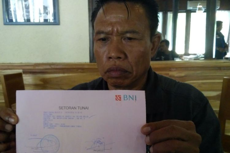 Wayan Kicen Adnyana menunjukan bukti transfer