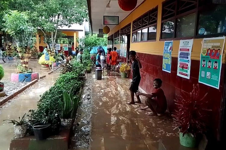 Pasca banjir yang merendam 3 desa dan 1 kelurahan di Kecamatan Bua, Kabupaten Luwu, Sulawesi Selatan, guru dan siswa berjibaku membersihkan ruang kelas dari material lumpur, Selasa (21/12/2021)