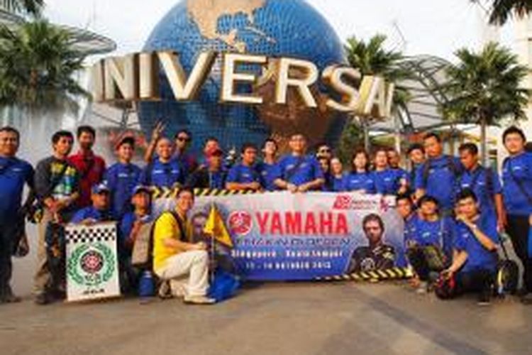 Para peserta rombongan Yamaha yang akan menyaksikan langsung GP Malaysia di Sirkuit Sepang, berpose di depan logo Universal Studio Singapore, Jumat (11/10/2013).