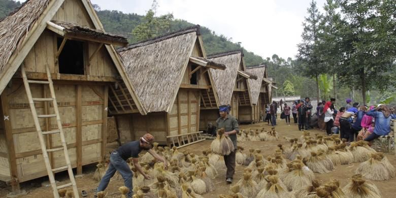 Warga adat Kasepuhan Ciptagelar, Kabupaten Sukabumi, Jawa Barat memasukkan padi ke dalam lumbung (leuit) komunal saat upacara seren taun, Minggu (24/8/2014). Seren taun adalah upacara adat untuk mensyukuri hasil panen padi selama satu tahun. KOMPAS IMAGES/KRISTIANTO PURNOMO