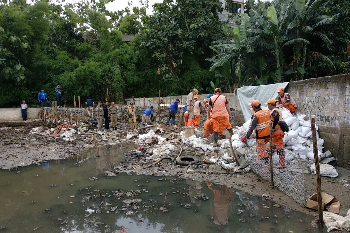 Pengerjaan tanggul jebol di Kampung Air, Jatipadang, Jakarta Selatan, Senin (18/12/2017).