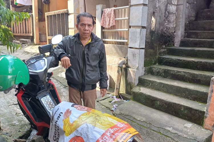 Seorang warga di Pasar Minggu bernama Herman (60) memungut alat peraga kampanye (APK) yang berada di Jalan Taman Margasatwa Raya, Jati Padang, Pasar Minggu, Jakarta Selatan. 