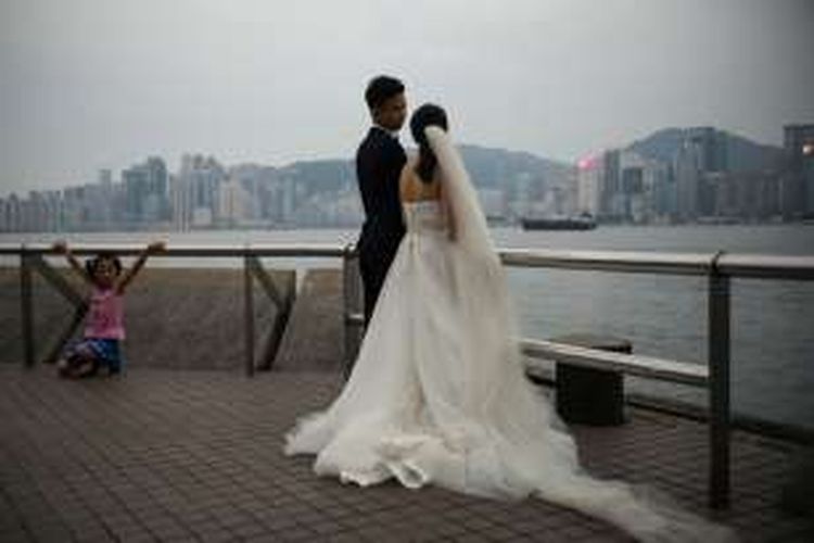 Sepasang pengantin baru di Hongkong masih sempat berpose meski peringatan kedatangan topan Nida sudah disampaikan pemerintah setempat Senin (1/8/2016).
