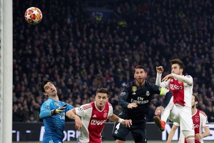 Nicolas Tagliafico lebih cepat daripada Thibaut Courtois dan Sergio Ramos yang coba memotong bola pada pertandingan Ajax Amsterdam vs Real Madrid di Johan Cruyff Arena dalam babak 16 besar Liga Champions. 