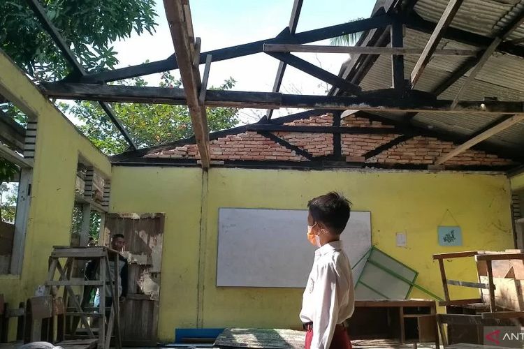 Seorang siswa melihat ruang kelas yang setengah atapnya telah hilang dicuri. 30 Lembar Atap di SDN 05 Siak Hulu Digondol Maling