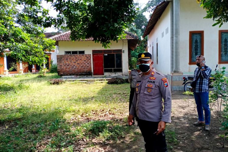 Seorang polisi berdiri di depan rumah warga Desa Bendowulung, Kecamatan Sanankulon, Kabupaten Blitar di mana seorang lansia berinisial D (61) ditemukan meninggal dengan kondisi jasad sudah dipenuhi belatung, Selasa (28/3/2023)