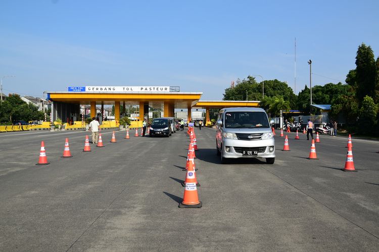 Polisi menerapkan ganjil genap di Tol Pasteur, Jumat (3/9/2021). Penerapan ganjil genap di lima tol Kota Bandung ini dilakukan untuk mengontrol arus kendaraan dari luar daerah masuk ke Kota Bandung.