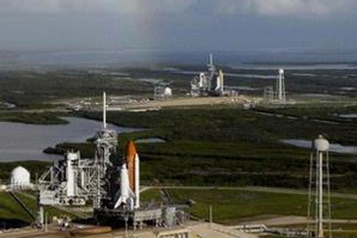 Dengan latar belakang pelangi, wahana ulang alik Atlantis (depan) berdiri tgak di Launch Pad A dan Endeavour (di belakang) di Launch Pad B Kennedy Space Center di Florida.