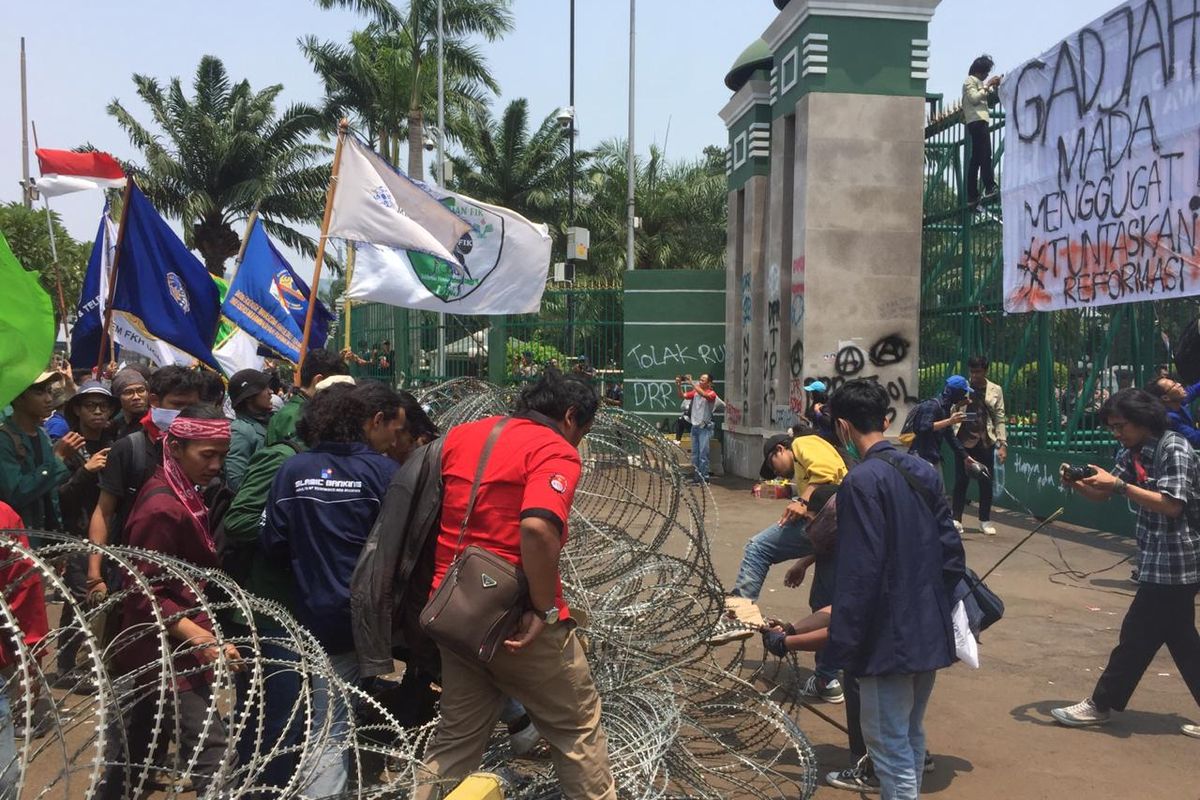 Massa mahasiswa merusak barier kawat berduri di depan Gedung DPR RI, Jalan Gatot Subroto, Jakarta Pusat, Selasa (24/9/2019).