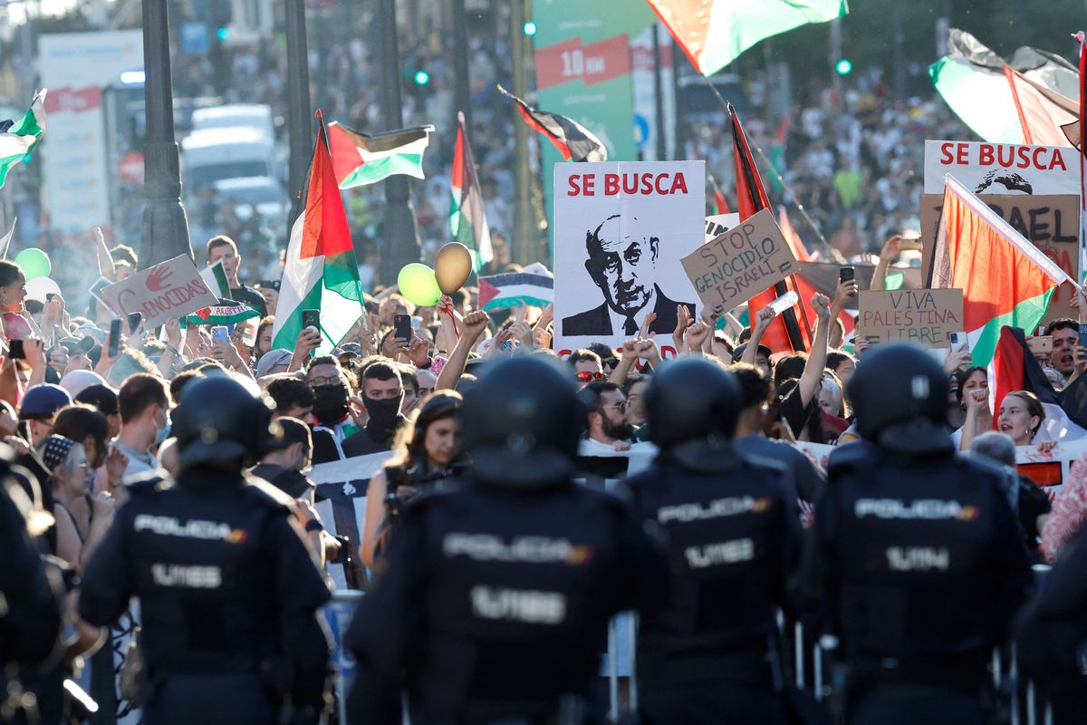 Para pengunjuk rasa pro-Palestina membentangkan spanduk bertuliskan (Perdana Menteri Israel Netanyahu) dicari setelah menyerbu jalan selama tahap ke-21 dan terakhir Vuelta a Espana 2025, di Madrid pada tanggal 14 September 2025. Karena kericuhan, etape final La Vuelta a Espana 2025 dibatalkan.
