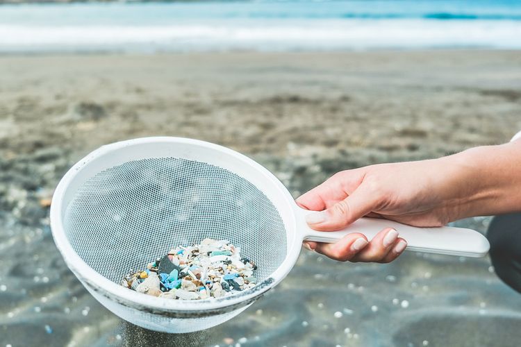 Ilustrasi mikroplastik di pantai yang mencemari laut. Dampak sampah plastik di lautan.