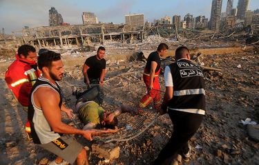 Petugas pemadam kebakaran mengevakuasi seorang yang terluka dari tempat ledakan di kawasan pelabuhan di Beirut, Ibu Kota Lebanon, Selasa (4/8/2020). Sebanyak 73 orang tewas dan ribuan lainnya dilaporkan terluka dari insiden dua ledakan besar yang mengguncang Beirut tersebut.