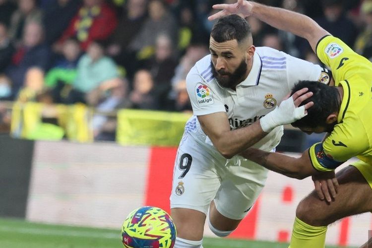 Karim Benzema (9) terlibat duel perebutan bola dengan Raul Albiol dalam laga pekan ke-16 Liga Spanyol 2022-2023 antara Villarreal vs Real Madrid di Estadio de La Ceramica, 7 Januari 2023. (Photo by JOSE JORDAN / AFP)